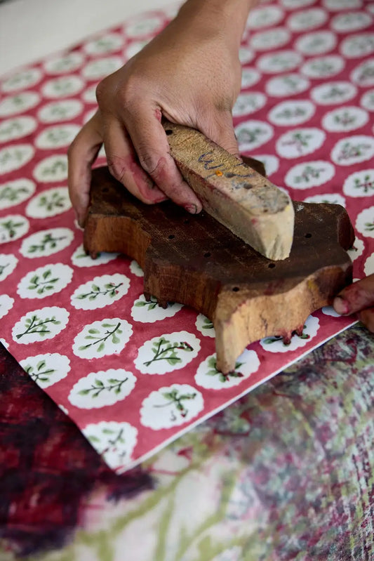 process of stamping red + green handmade block printed christmas wrapping paper