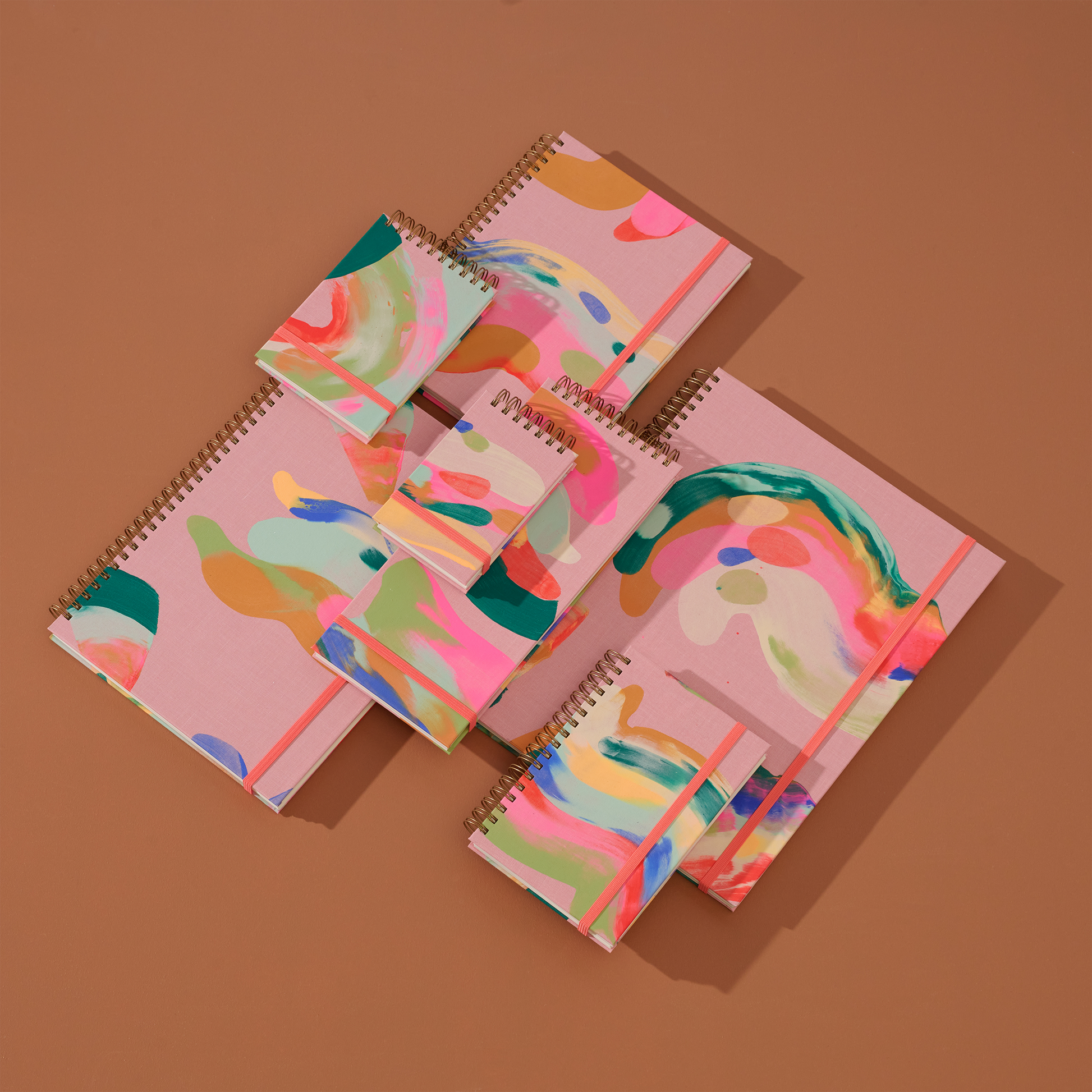 moglea Colorful spiral-bound notebooks on a brown background