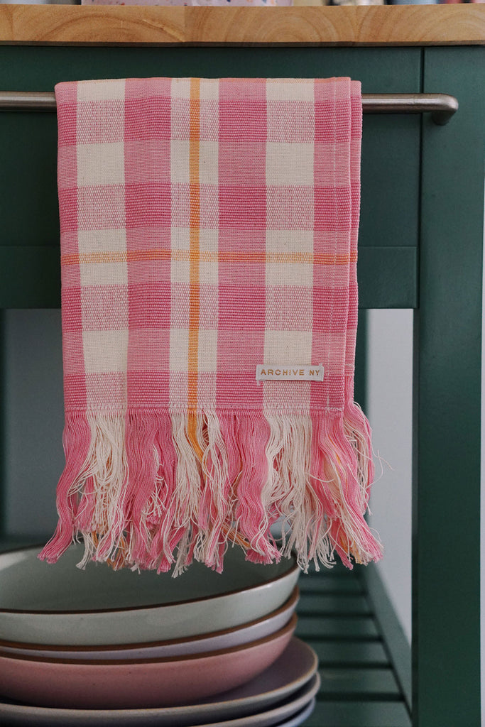 pink and orange plaid kitchen towel hanging on kitchen cart