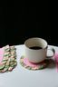 cute drink coasters and pink + green cloth napkins on a dining table