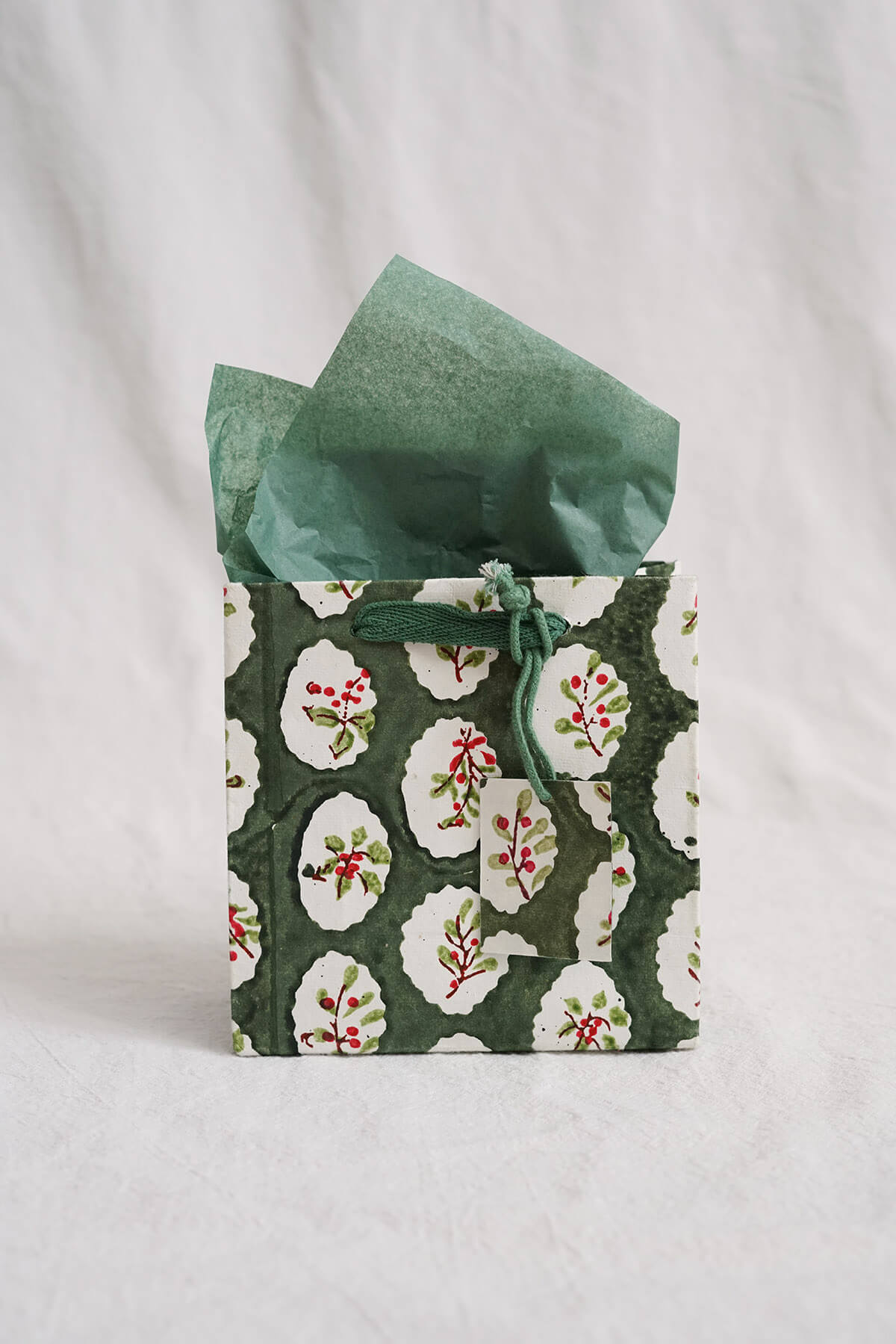 green small holiday gift bag with handpainted holly details