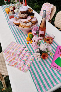 summer brunch table with colorful decorations and donut cake stand