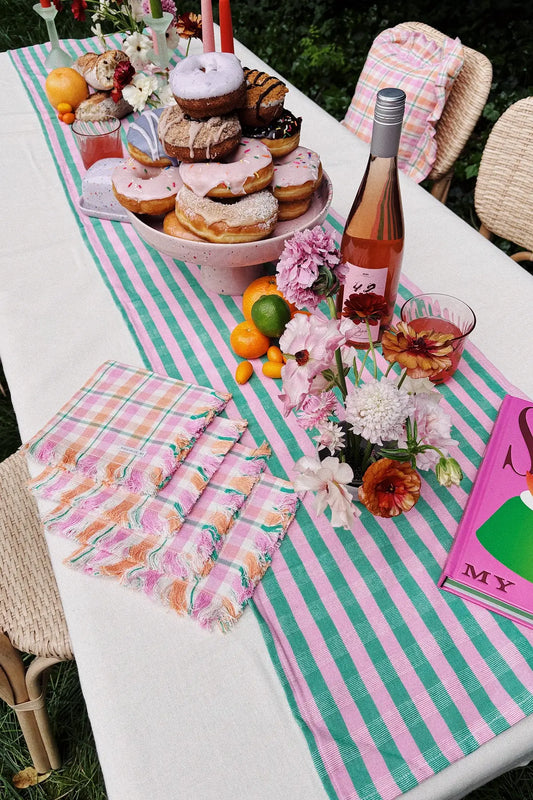 summer brunch table with colorful decorations and donut cake stand