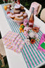 summer brunch table with colorful decorations and donut cake stand