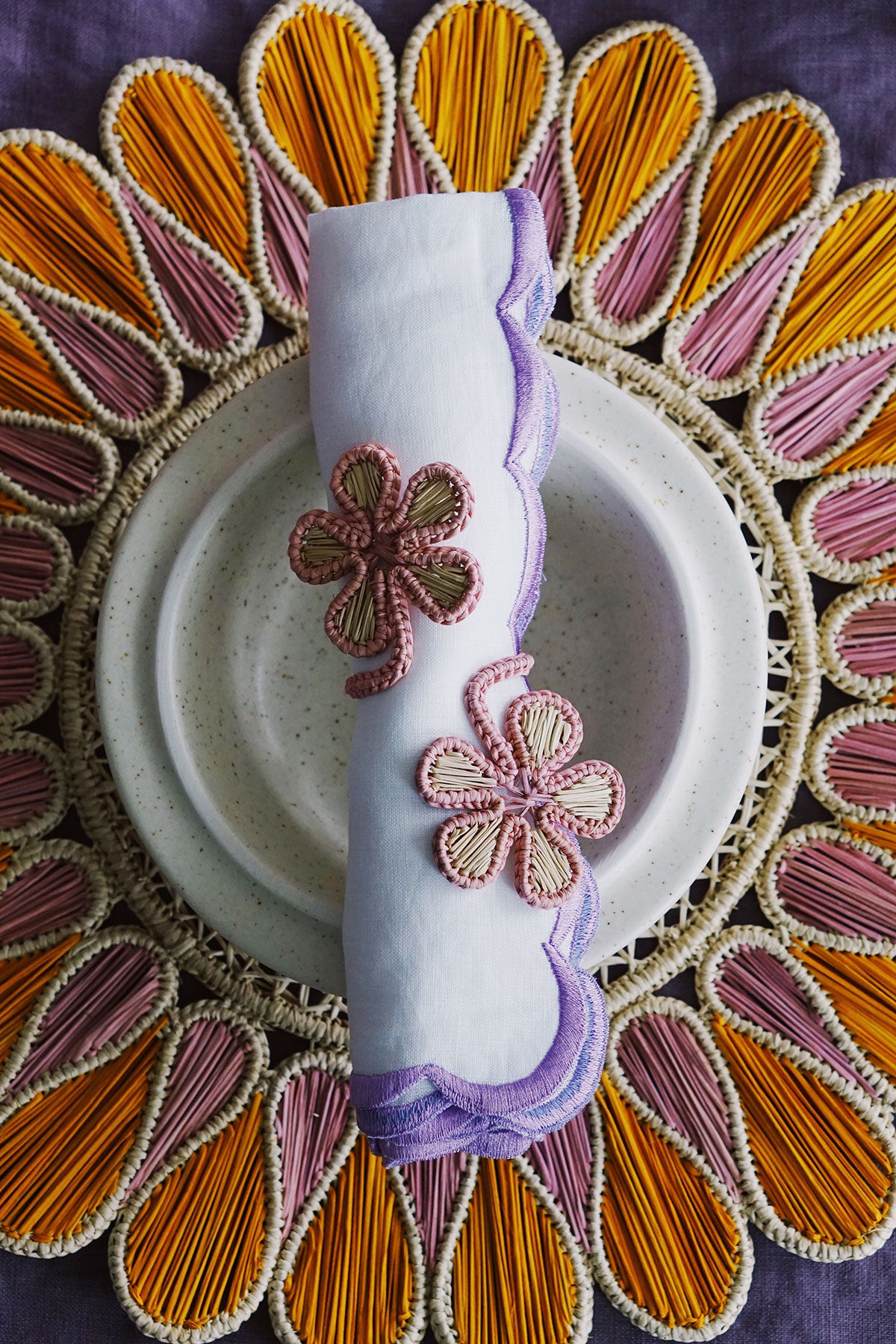 bright spring brunch place setting with woven placemat and floral napkin rings from wallflower