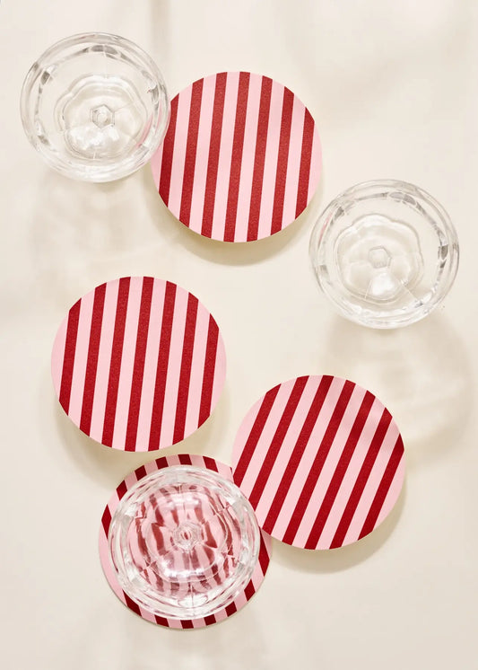 Red and pink coasters with clear glass bowls on a light background