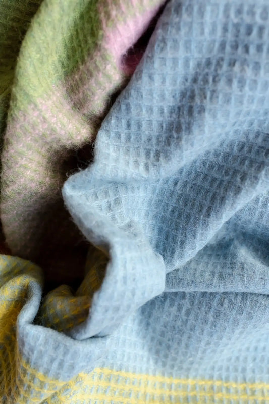 close up of pastel plaid wool blanket in pink, green, blue and yellow