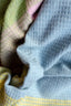 close up of pastel plaid wool blanket in pink, green, blue and yellow