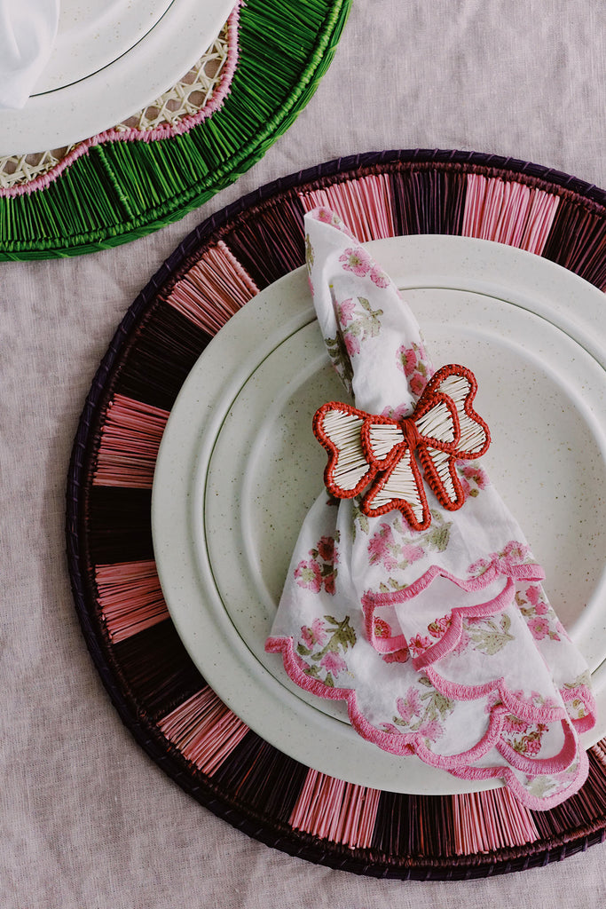 pink woven placemats with red bow napkin ring and pink floral napkin