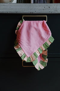 pink and green cloth napkin hanging from dark cabinets