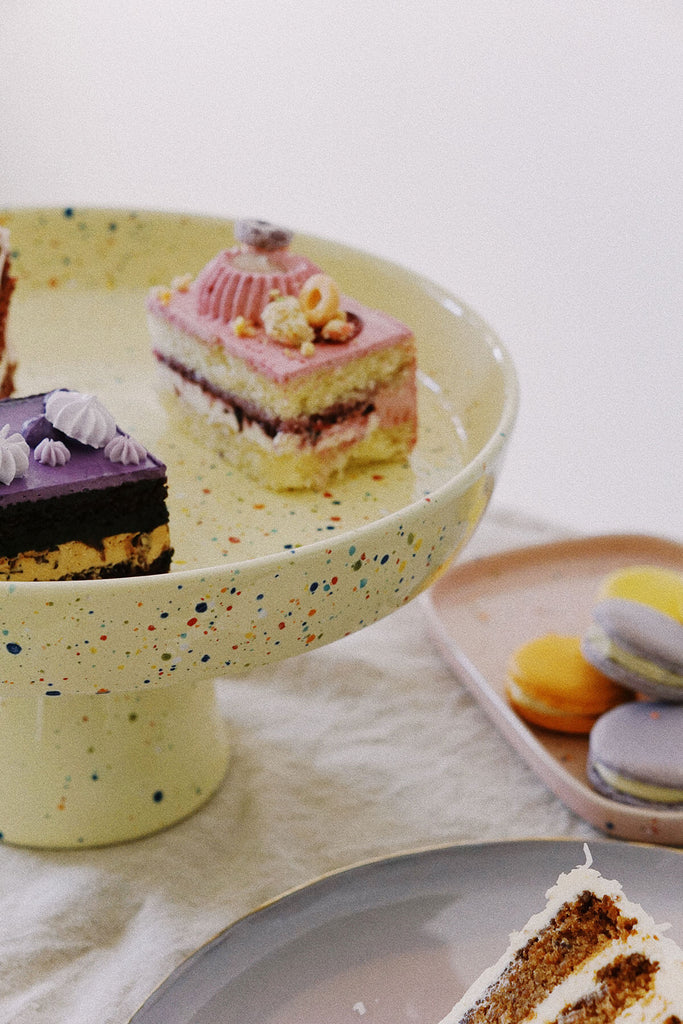 yellow ceramic cake stand and pastel desserts